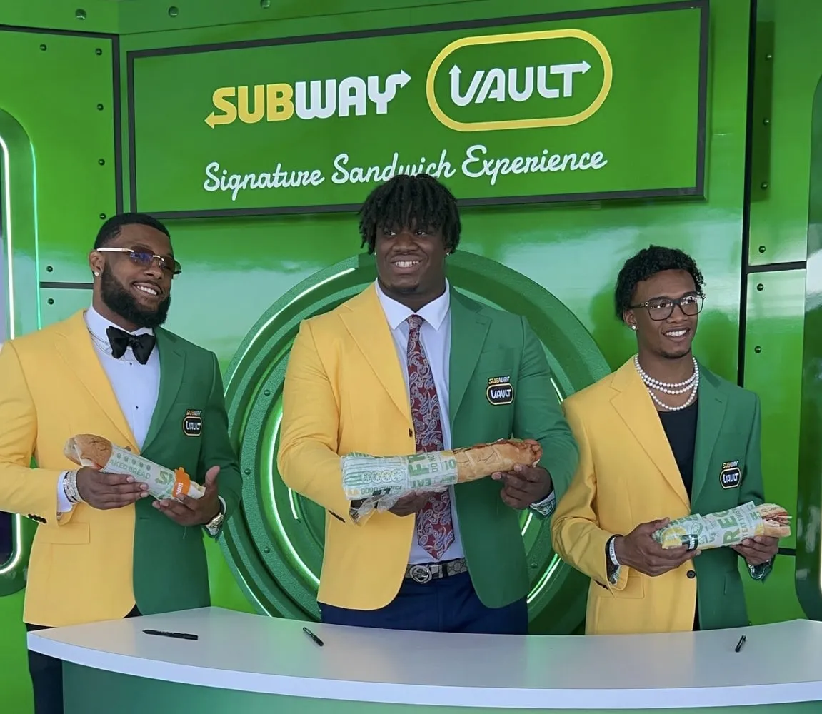 Photo of a man wearing a green a yellow blazer branded with Subway food chain